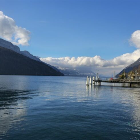 Mountain landscape with a calm lake reflecting the scenery under a cloudy sky.