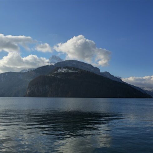 Mountain landscape with a calm lake reflecting the scenery under a cloudy sky.