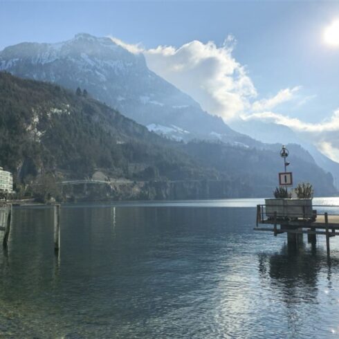 Mountain landscape with a calm lake reflecting the scenery under a cloudy sky.