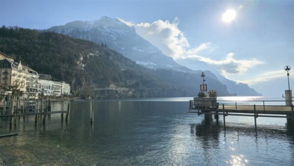 Mountain landscape with a calm lake reflecting the scenery under a cloudy sky.
