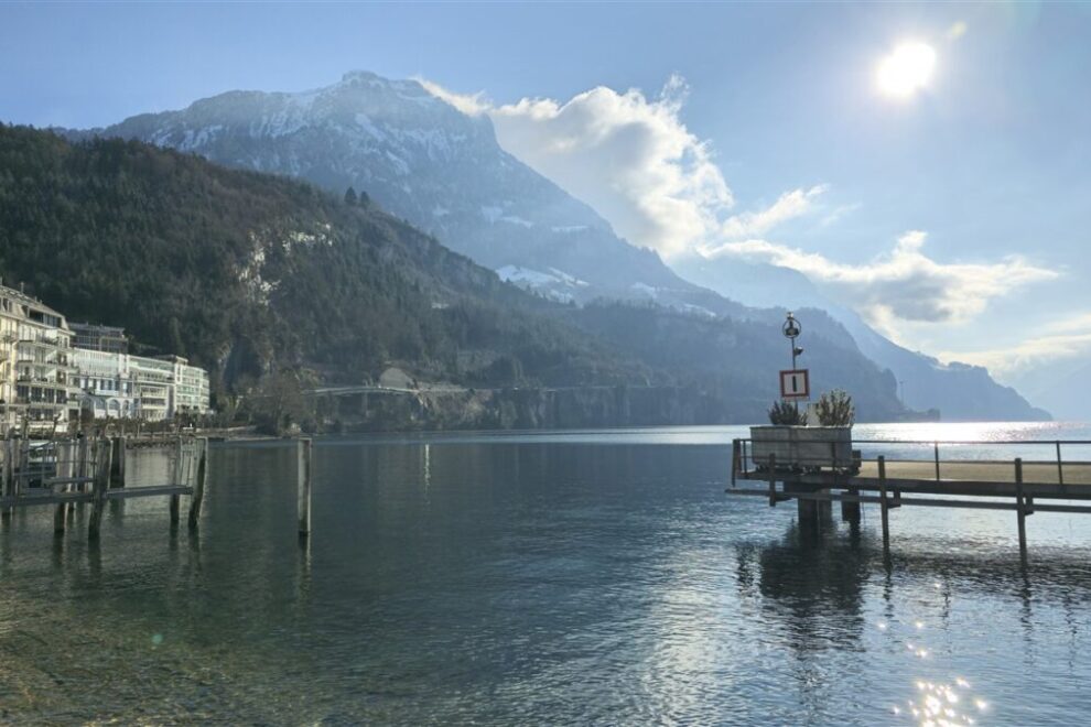 Mountain landscape with a calm lake reflecting the scenery under a cloudy sky.