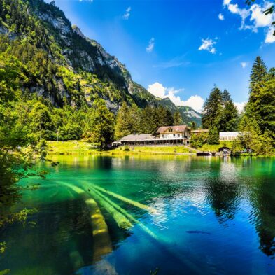 Winding road over Furka Pass with dramatic views of the Swiss Alps and distant glaciers