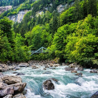 Winding road over Furka Pass with dramatic views of the Swiss Alps and distant glaciers