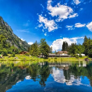 Winding road over Furka Pass with dramatic views of the Swiss Alps and distant glaciers