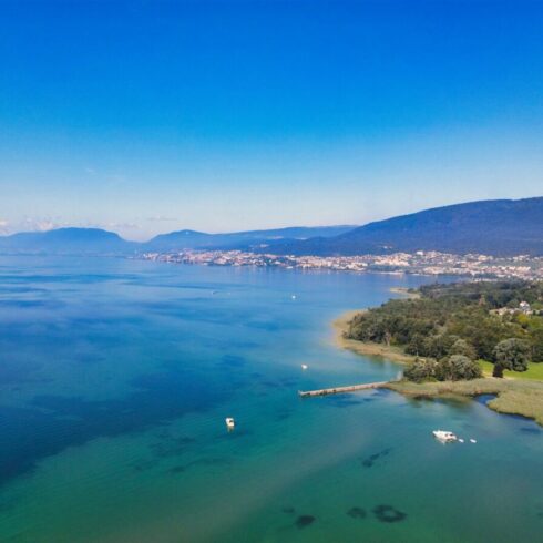 Snow-covered Swiss Alps under a bright blue sky with dramatic cloud formations