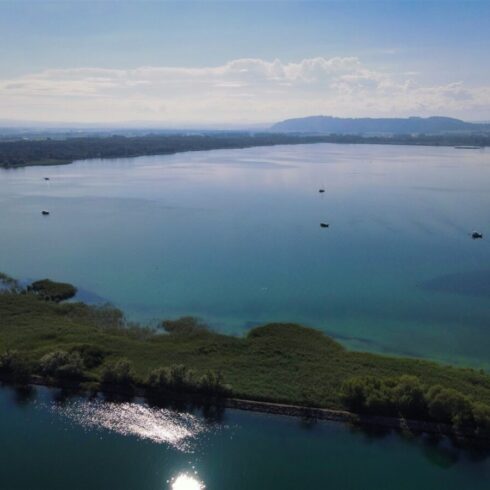 Crystal-clear alpine lake surrounded by towering mountain peaks and lush forests