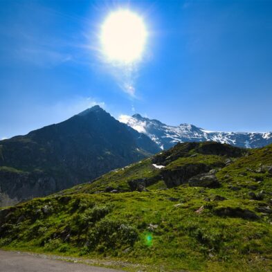 Traditional Swiss village nestled in a green valley with alpine slopes rising in the background