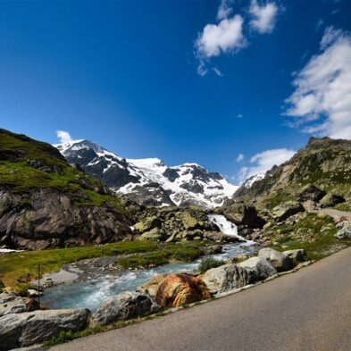 Traditional Swiss village nestled in a green valley with alpine slopes rising in the background