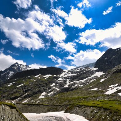 Traditional Swiss village nestled in a green valley with alpine slopes rising in the background