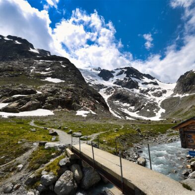 Traditional Swiss village nestled in a green valley with alpine slopes rising in the background