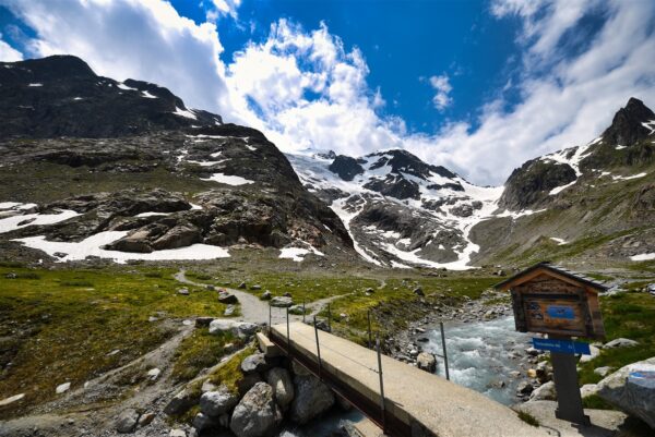 Traditional Swiss village nestled in a green valley with alpine slopes rising in the background