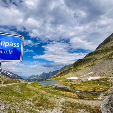 Traditional Swiss village nestled in a green valley with alpine slopes rising in the background
