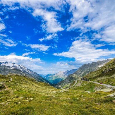 Traditional Swiss village nestled in a green valley with alpine slopes rising in the background