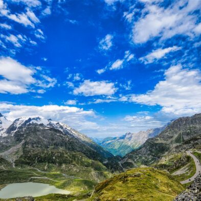 Traditional Swiss village nestled in a green valley with alpine slopes rising in the background