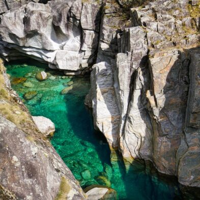 Crystal-clear alpine lake surrounded by towering mountain peaks and lush forests