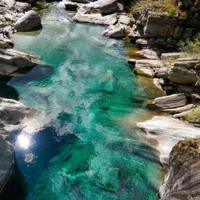 Crystal-clear alpine lake surrounded by towering mountain peaks and lush forests