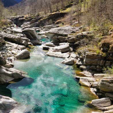 Crystal-clear alpine lake surrounded by towering mountain peaks and lush forests