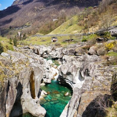 Crystal-clear alpine lake surrounded by towering mountain peaks and lush forests