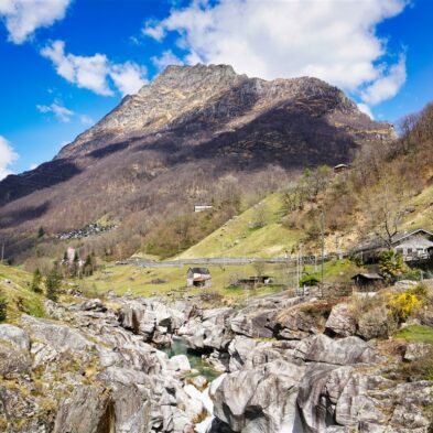 Crystal-clear alpine lake surrounded by towering mountain peaks and lush forests