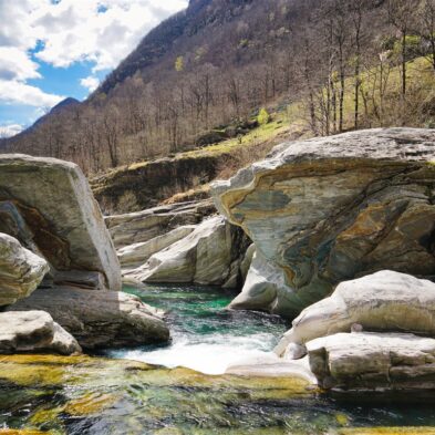 Crystal-clear alpine lake surrounded by towering mountain peaks and lush forests