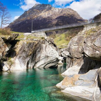 Crystal-clear alpine lake surrounded by towering mountain peaks and lush forests