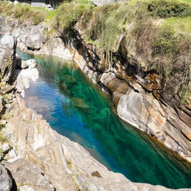 Crystal-clear alpine lake surrounded by towering mountain peaks and lush forests