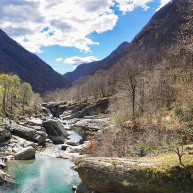 Crystal-clear alpine lake surrounded by towering mountain peaks and lush forests